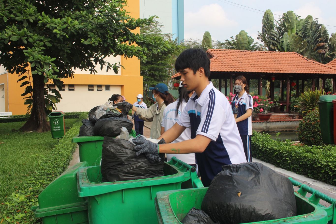 Các bạn đang thu gom rác thải tại khu vực trong trường.